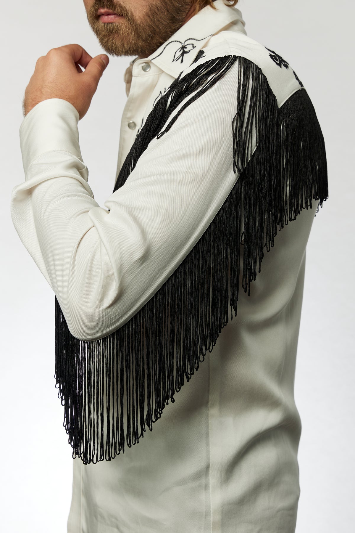 Side view of the black fringe on the sleeve and yoke of the H Bar C Taos white western shirt.