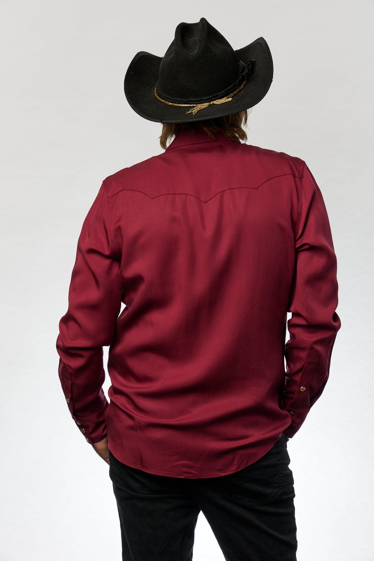 Back view of the H Bar C Kansas City wine shirt with triple back yoke and a black hat.